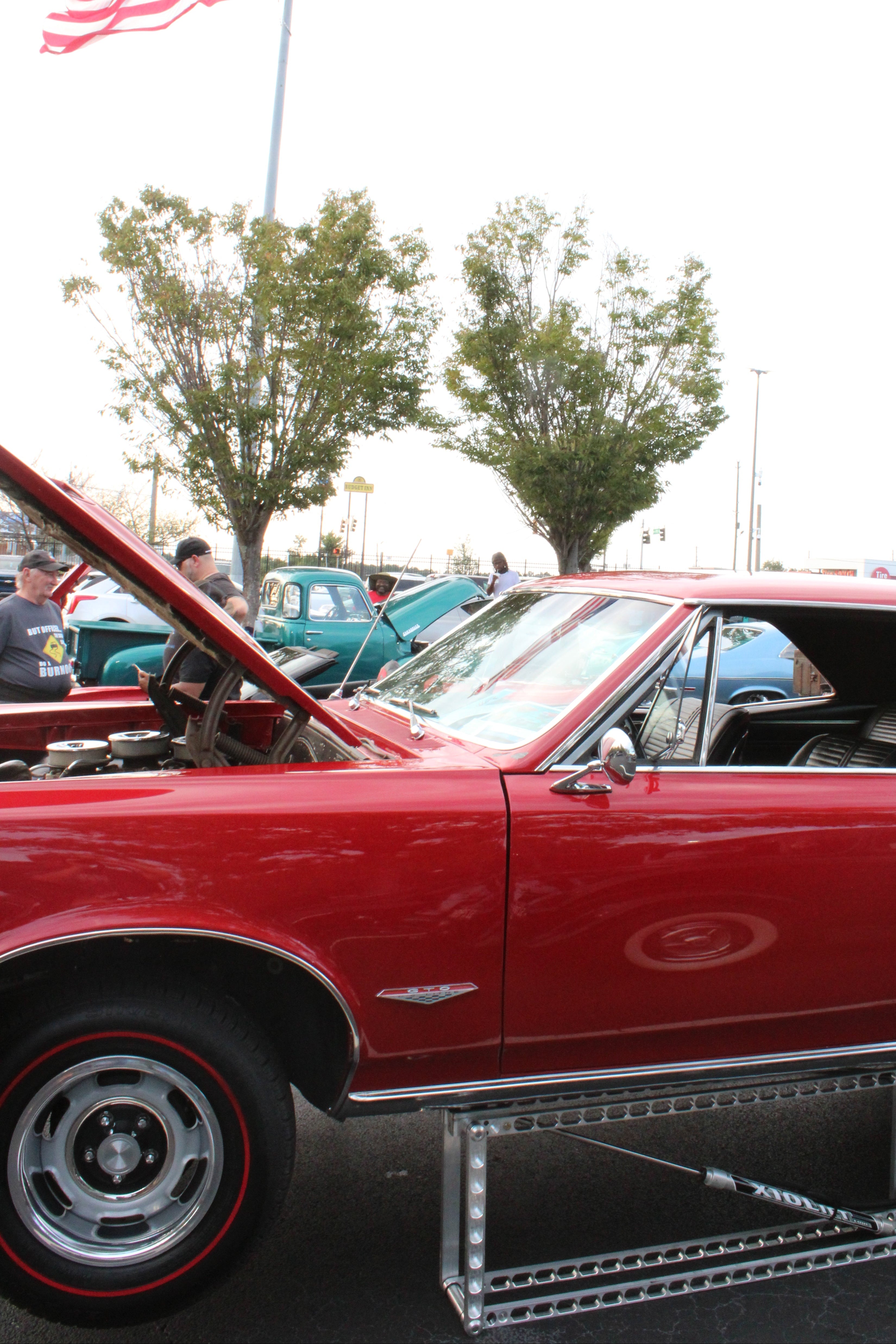 Pontiac GTO 1966 being lifted by the X10(XS) with a flag in the back.